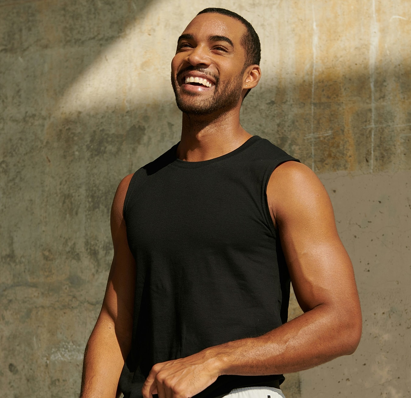 Smiling man in a black tank top.