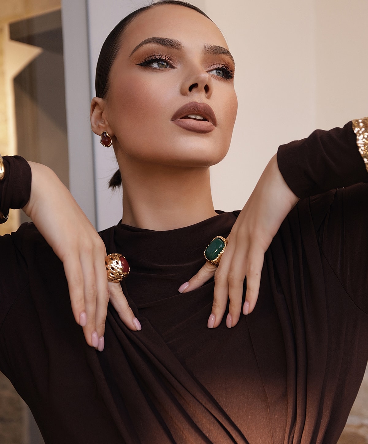 Woman showcasing jewelry in elegant outfit.