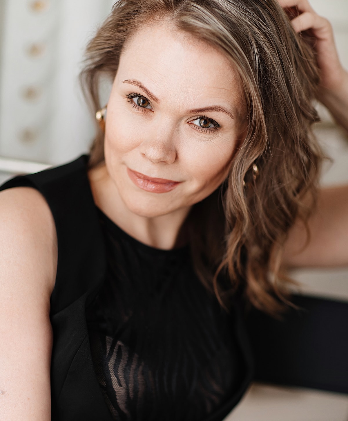 Woman with curly hair smiling confidently.