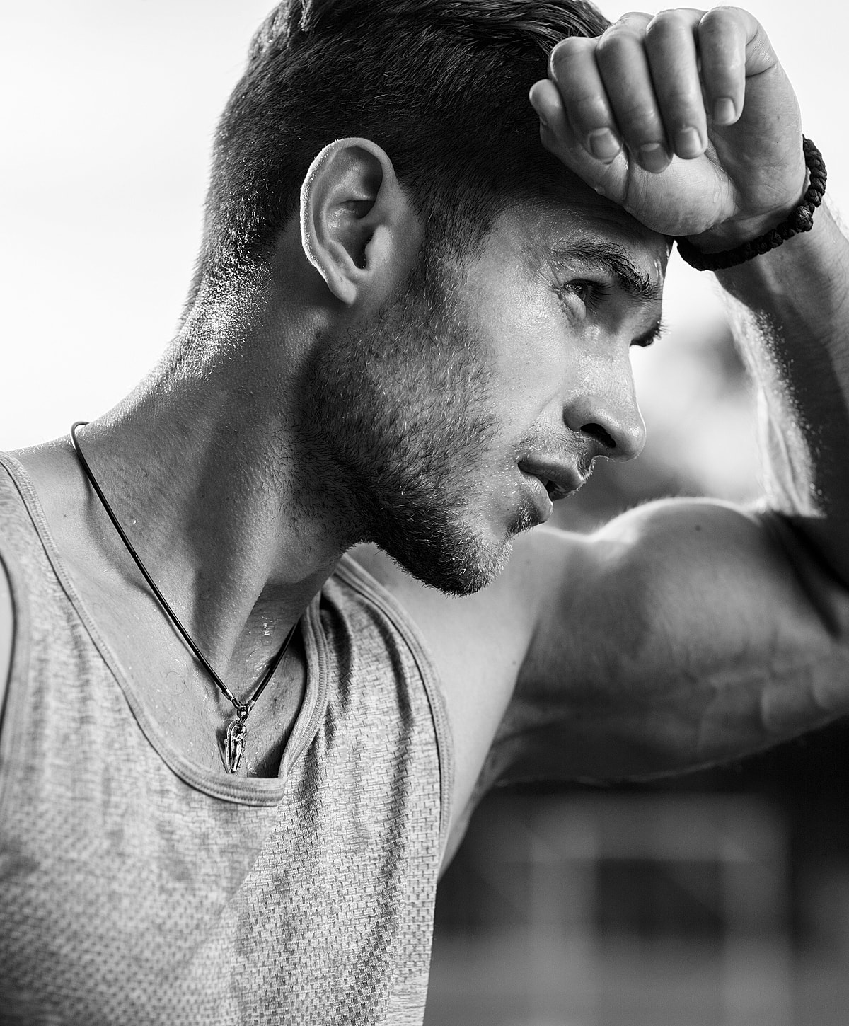 Man wiping sweat, intense workout moment.