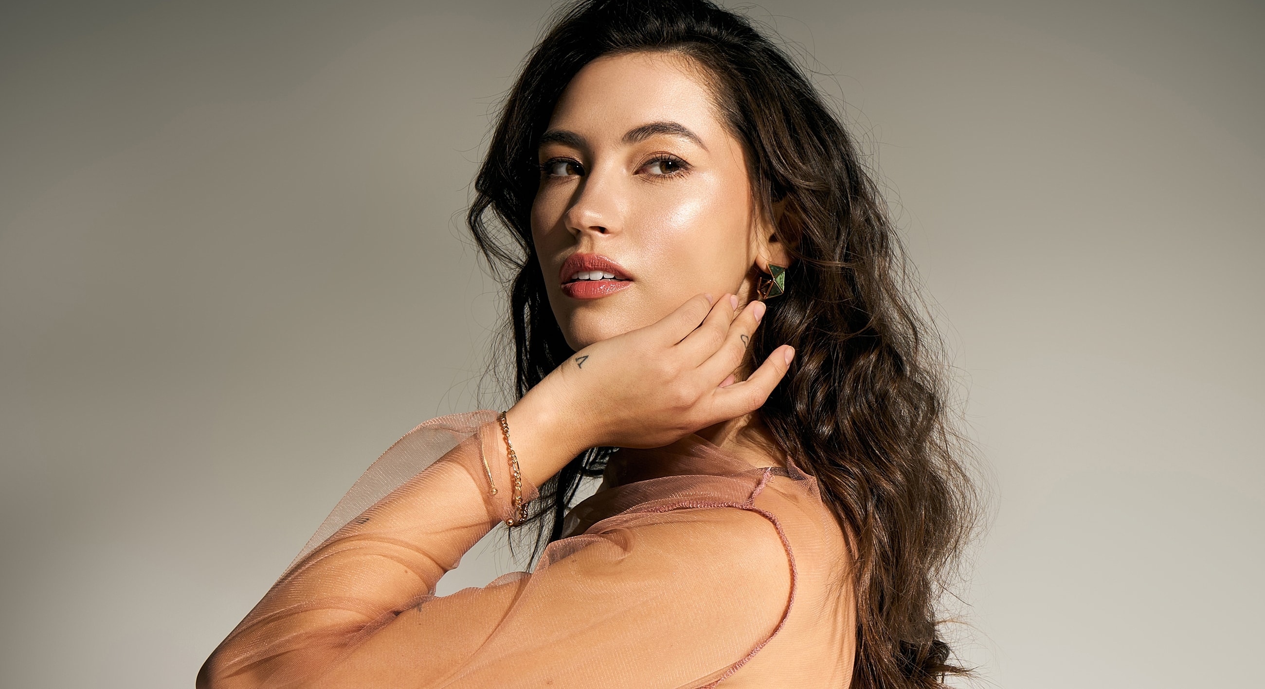 Woman in elegant attire with soft makeup.