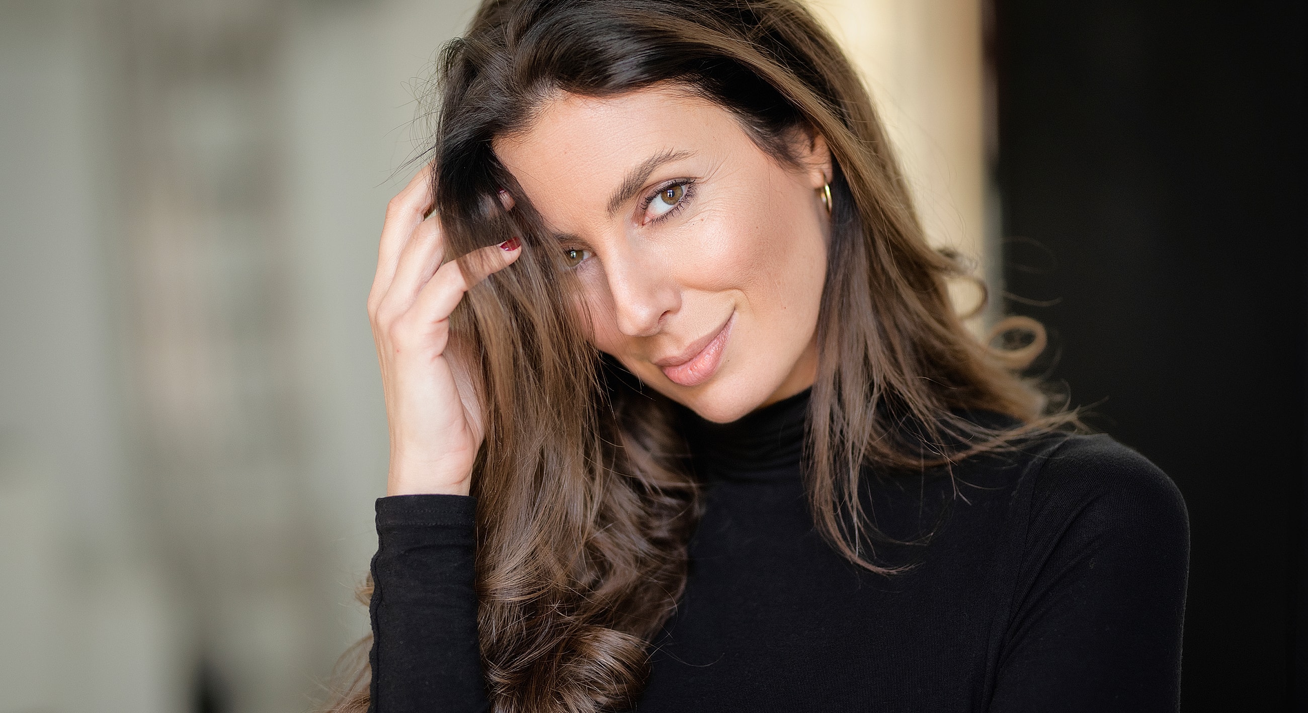 Woman with long hair in black turtleneck.