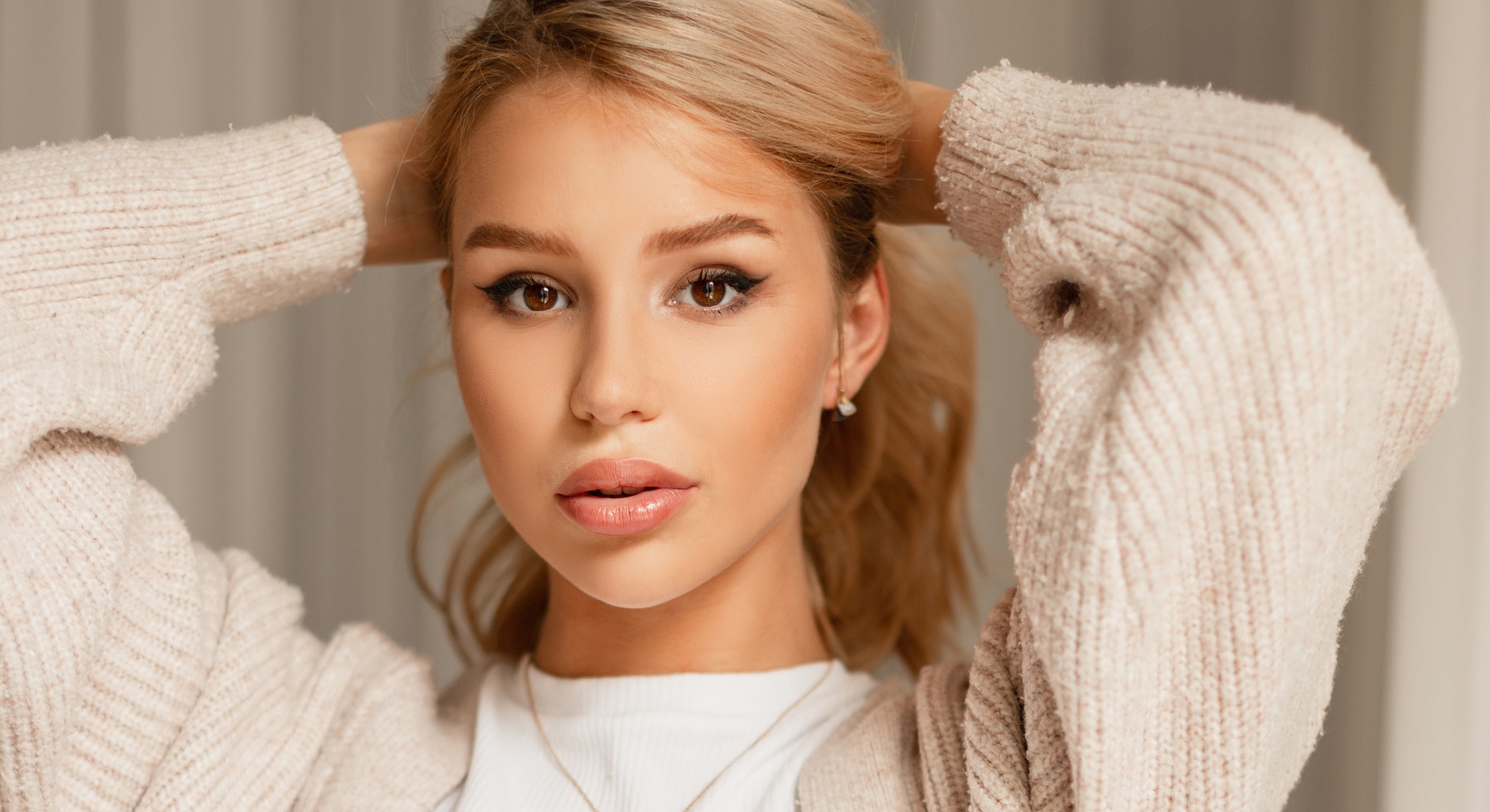 Young woman with stylish hairstyle and makeup.